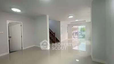 Spacious modern living room with glossy tiled floors and natural light