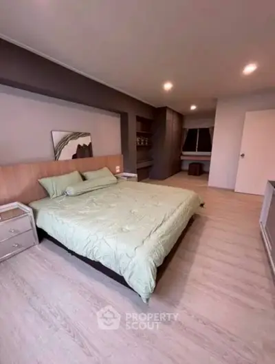 Spacious modern bedroom with elegant decor and ample natural light.