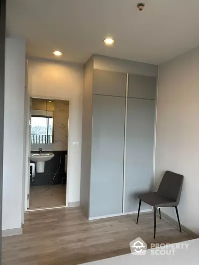 Modern minimalist bedroom with sleek wardrobe and bathroom view