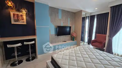 Modern bedroom with stylish decor, featuring a mounted TV, cozy seating, and elegant lighting.