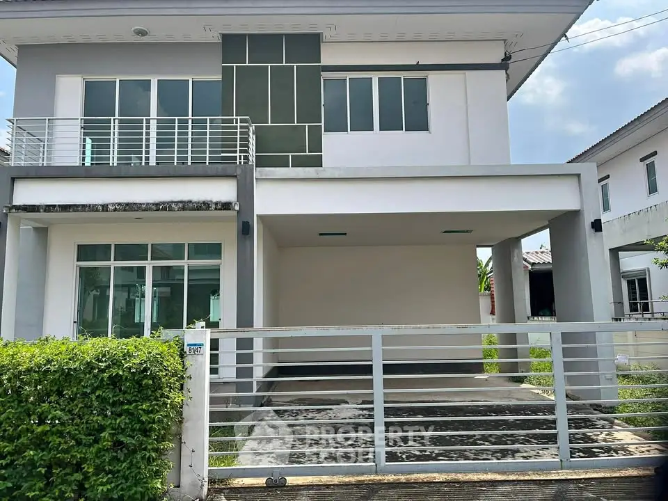 Modern two-story house with spacious driveway and sleek design in a suburban neighborhood.