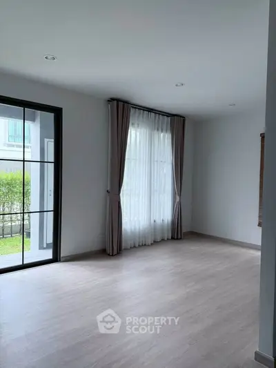 Spacious empty living room with large window and garden view