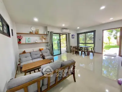 Spacious living room with modern furniture and garden view, perfect for family gatherings.