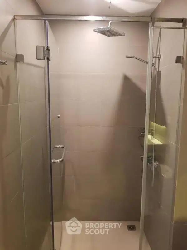 Modern bathroom with glass shower enclosure and rainfall showerhead.