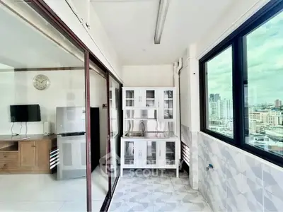 Bright kitchen with city view, featuring modern cabinetry and large windows for natural light.