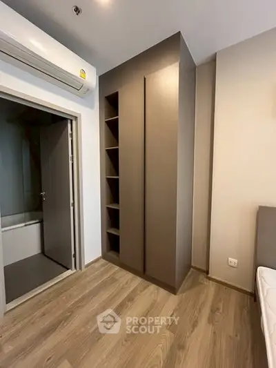 Modern bedroom with built-in wardrobe and ensuite bathroom in a stylish apartment.