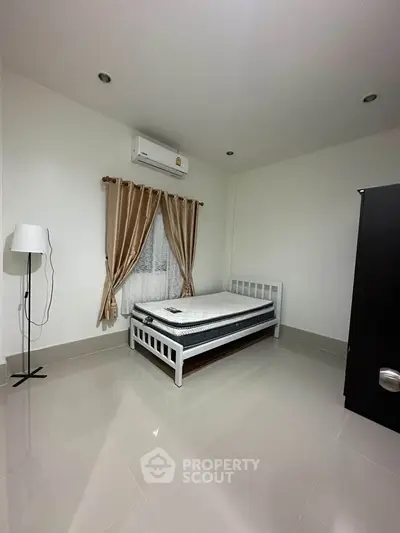 Minimalist bedroom with single bed, air conditioning, and modern decor
