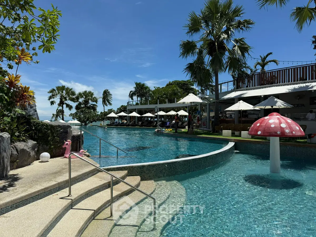 Luxurious resort-style pool area with palm trees and sun loungers, perfect for relaxation and leisure.