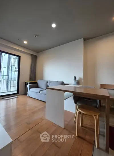 Modern living room with wooden flooring, cozy sofa, and dining area in open layout apartment.