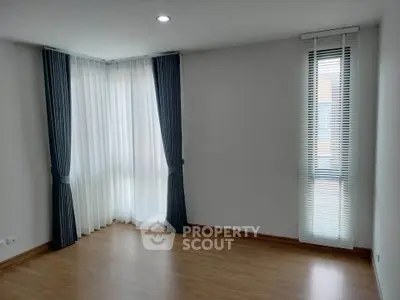Spacious empty room with elegant floor-to-ceiling windows and stylish curtains, perfect for customization.