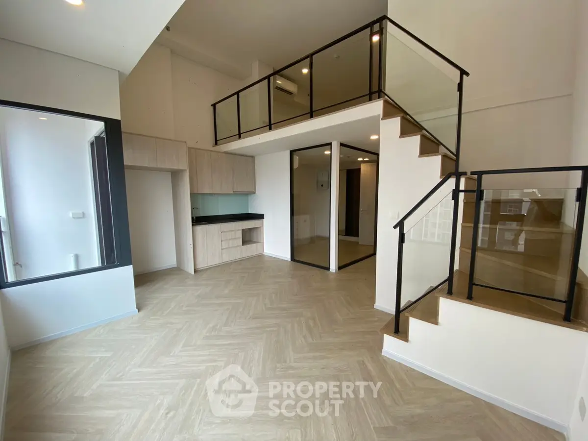 Modern duplex apartment with mezzanine and sleek glass railings