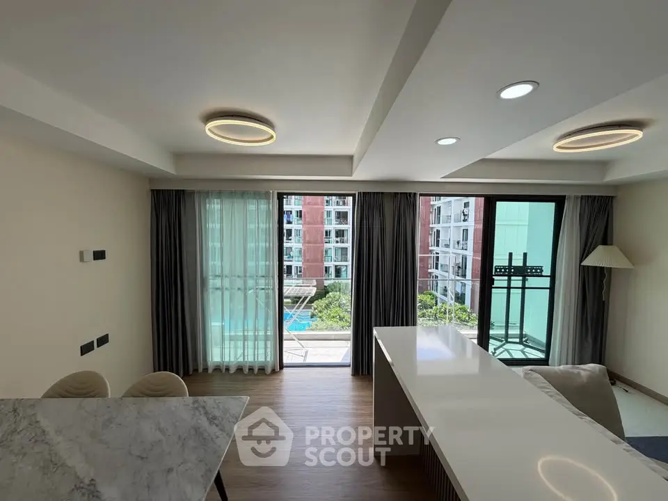 Modern living room with pool view and stylish lighting in a contemporary apartment.