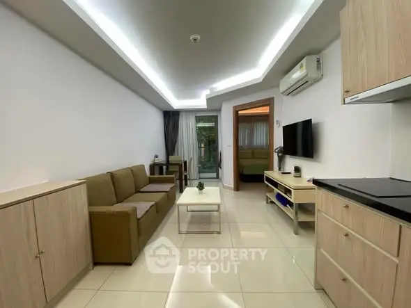 Modern living room with sleek furniture and open layout, featuring a cozy sofa and wall-mounted TV.