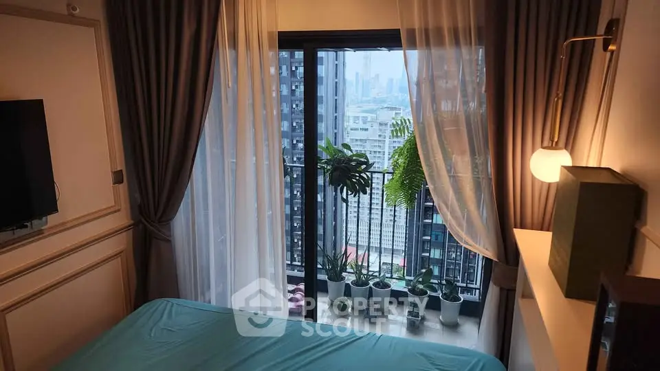 Chic bedroom with balcony offering stunning city views and lush greenery.