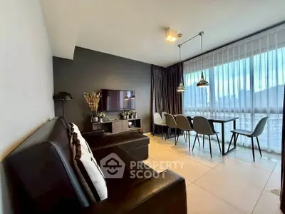 Modern living room with sleek furniture and large windows offering city views.