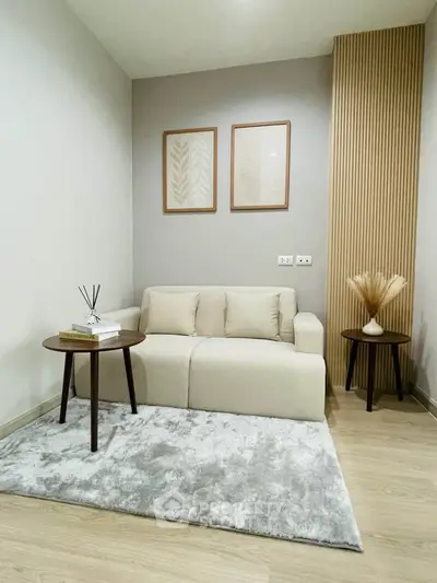 Cozy living room with modern decor and neutral tones, featuring a plush sofa and stylish side tables.