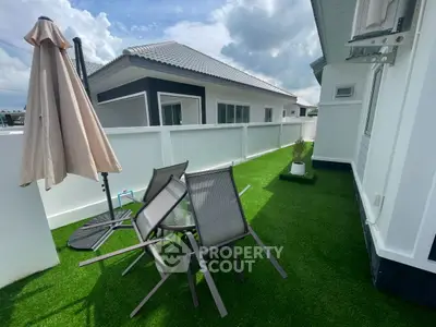 Charming rooftop terrace with artificial grass and outdoor seating, perfect for relaxation.