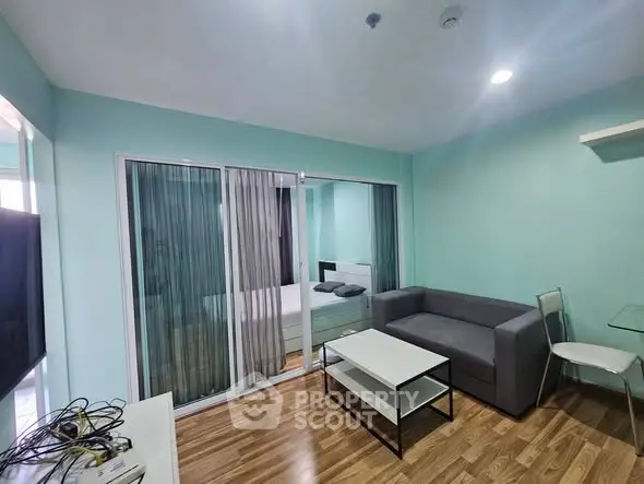 Modern living room with sleek furniture and wooden flooring in a stylish apartment.