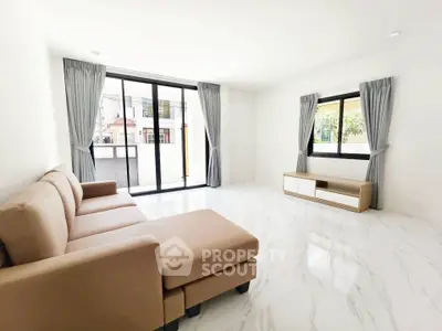 Spacious modern living room with large windows and elegant beige sofa