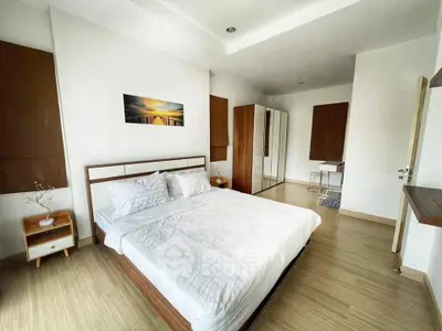 Spacious modern bedroom with elegant wooden flooring and stylish decor