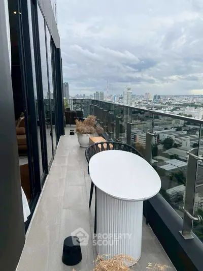 Stunning high-rise balcony with panoramic city views and modern outdoor seating.
