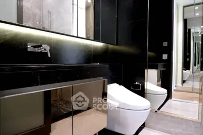 Luxurious modern bathroom with sleek black finishes and elegant lighting.