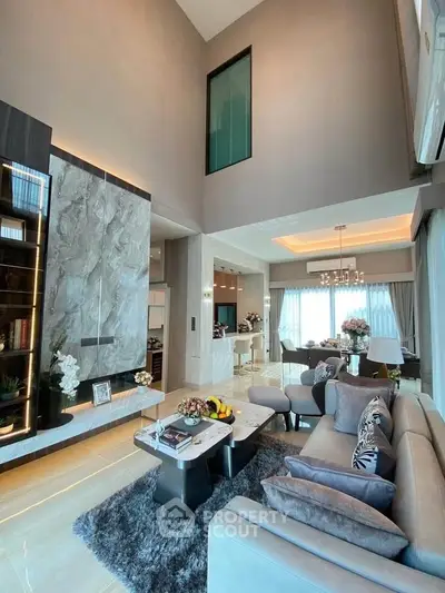 Luxurious double-height living room with elegant decor and modern furnishings.