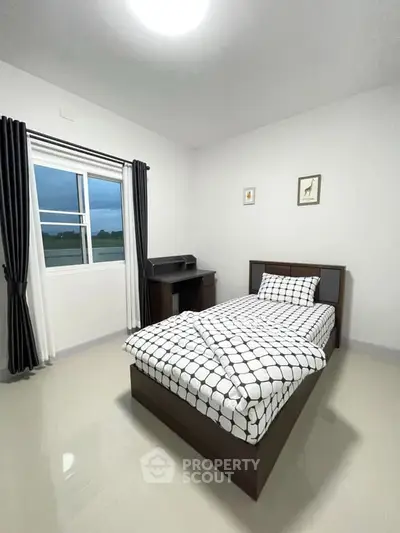 Cozy bedroom with single bed and modern decor, perfect for relaxation.