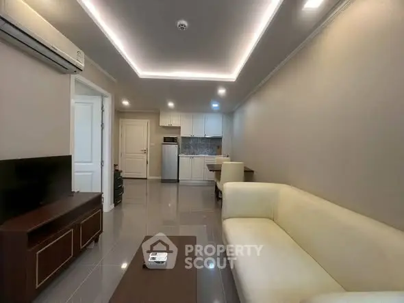 Modern living room with sleek design and open kitchen layout, featuring cozy seating and stylish decor.