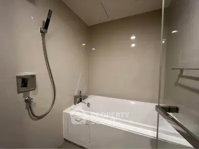 Modern bathroom with sleek bathtub and showerhead in a contemporary design.