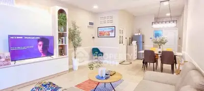 Spacious living room with modern decor and dining area, featuring stylish furniture and ambient lighting.