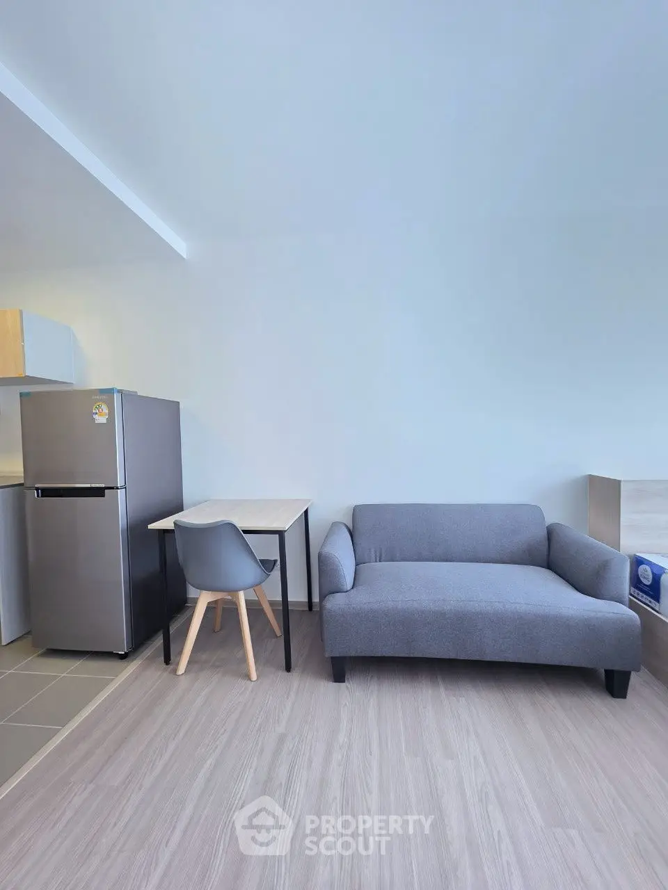 Modern studio apartment with sleek furniture and compact kitchen area.