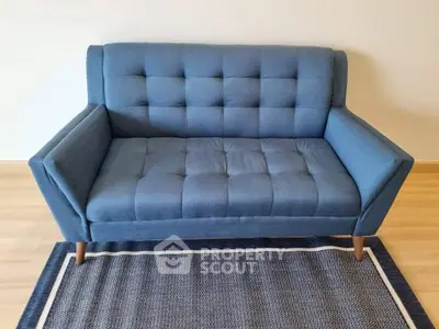 Stylish blue sofa on a modern rug in a cozy living room setting