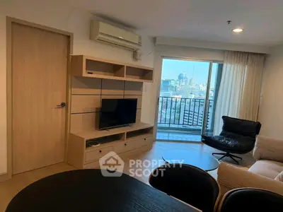 Modern living room with city view, featuring sleek furniture and a wall-mounted TV unit.
