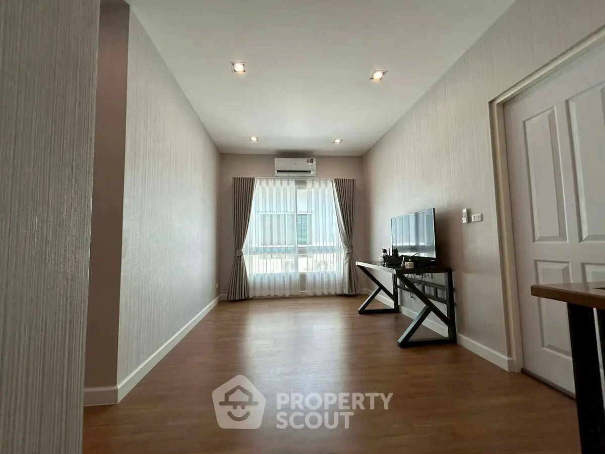 Spacious modern living room with wooden flooring and natural light