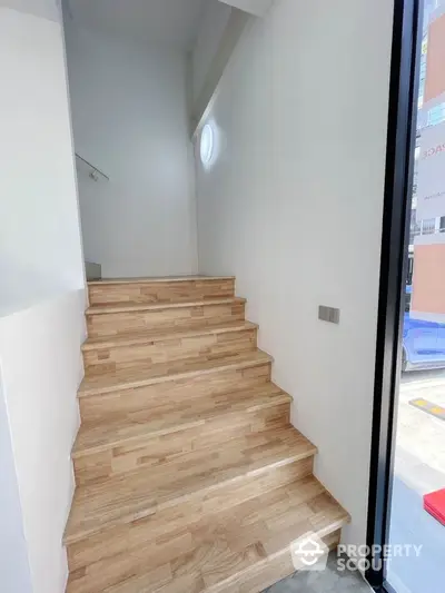 Modern wooden staircase with natural light and sleek design