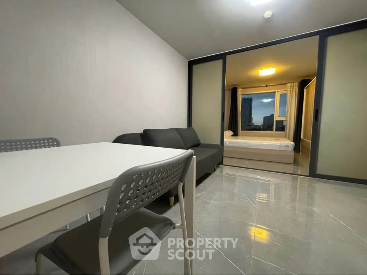 Modern apartment with sleek living area and cozy bedroom, featuring stylish furniture and city view.