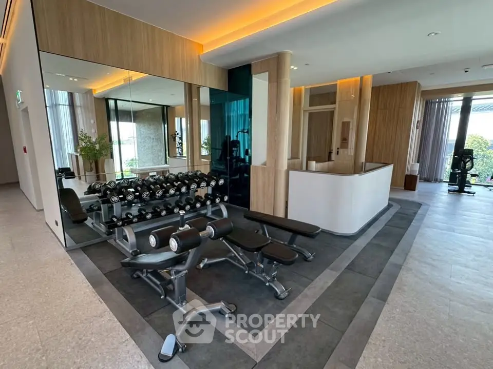 Modern gym with state-of-the-art equipment and sleek design in luxury residential building.