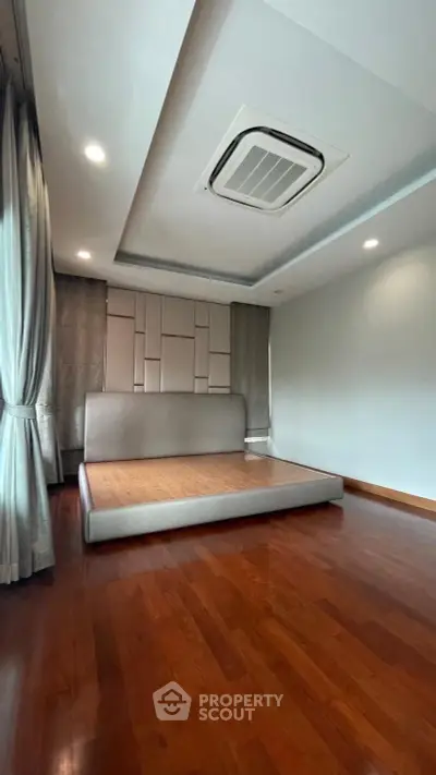Spacious bedroom with modern design and wooden flooring