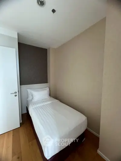 Cozy single bedroom with minimalist design and wooden flooring