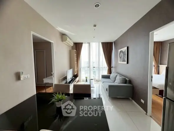 Modern living room with sleek furniture and large windows offering natural light.