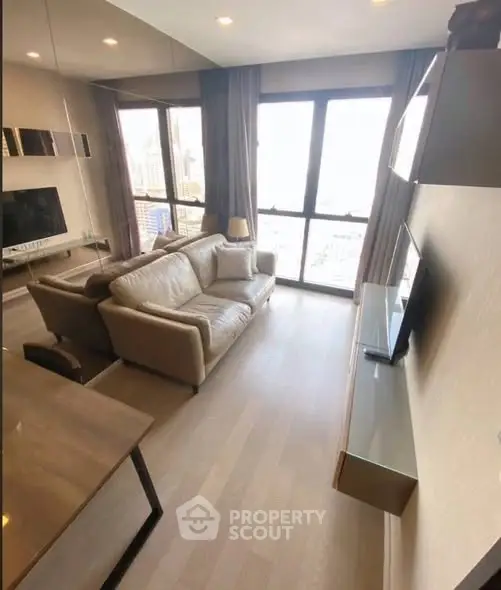 Modern living room with large windows and stylish furniture in a high-rise apartment.