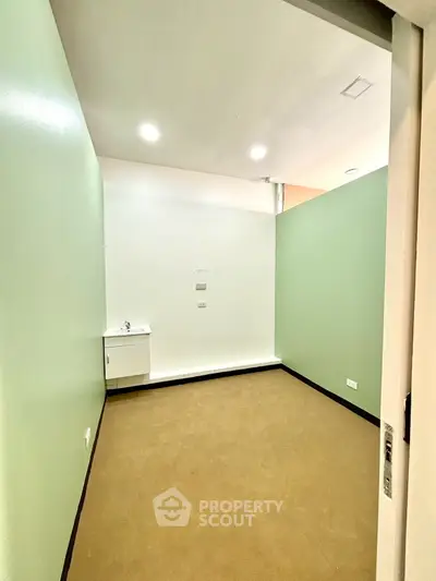 Spacious room with minimalist design and built-in sink, ideal for versatile use.