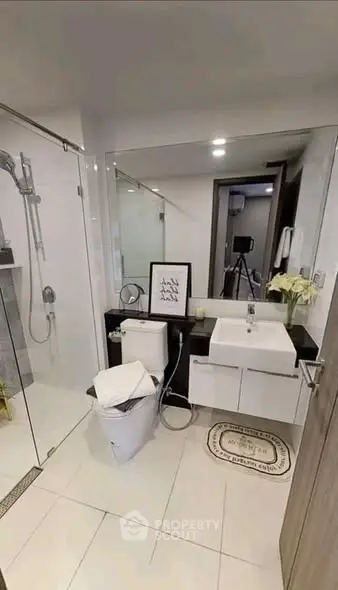 Modern bathroom with glass shower, sleek vanity, and contemporary decor