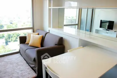 Modern living room with large window and stylish furniture in a high-rise apartment.
