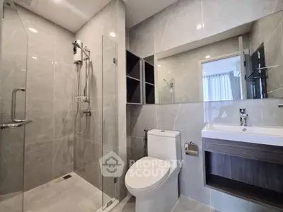 Modern bathroom with sleek design, glass shower, and elegant fixtures in a contemporary apartment.