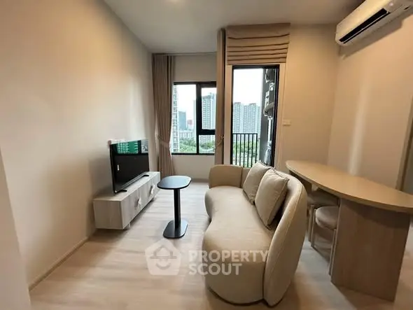 Modern living room with cozy sofa, TV, and city view from window in stylish apartment.