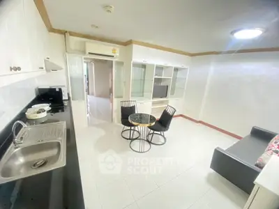 Spacious living room with modern furnishings and open kitchen layout