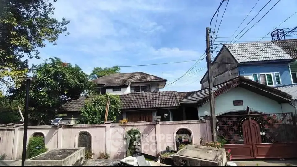 Charming suburban house with tiled roof and lush greenery, perfect for family living.