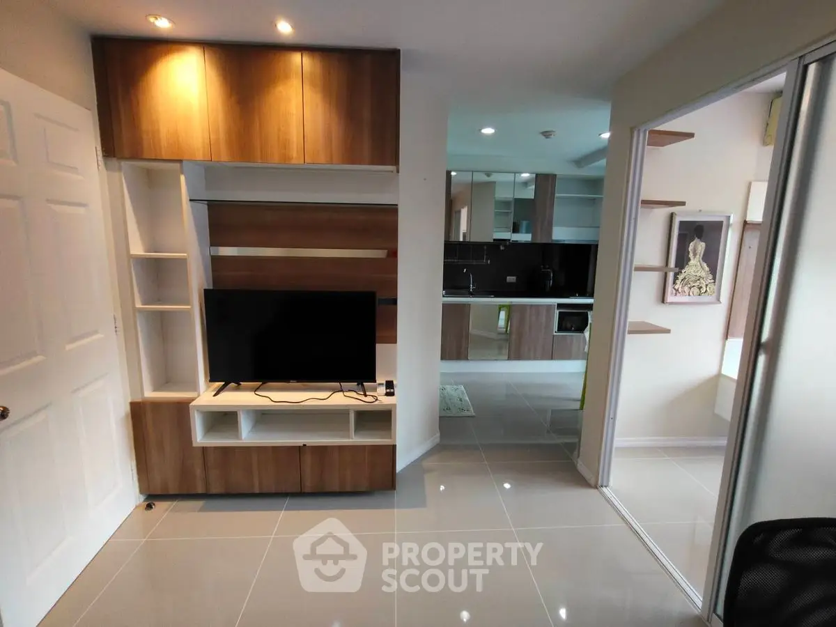 Modern open-plan living room with sleek kitchen and stylish wooden cabinetry.